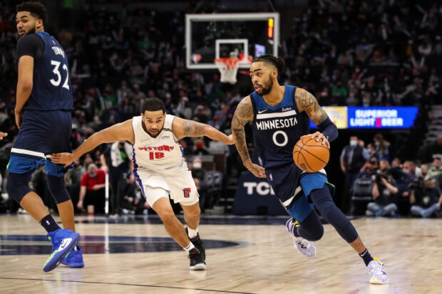 A Detroit Pistons player defending against a Minnesota basketball player in an intense game situation