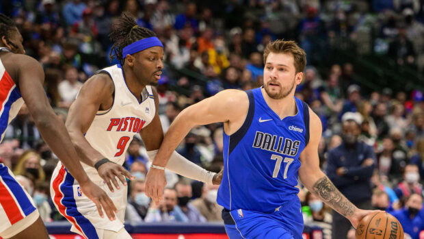 Detroit Pistons player defending against a Dallas player in an intense basketball game