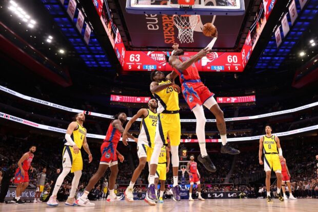 Detroit Pistons player jumping to score against Indiana Pacers in a basketball game