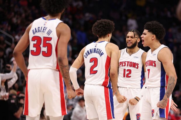 Detroit Pistons players celebrating during a basketball game in Detroit Pistons uniforms