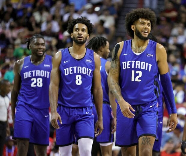 Detroit Pistons players walking on the court during a game in blue jerseys with Detroit text