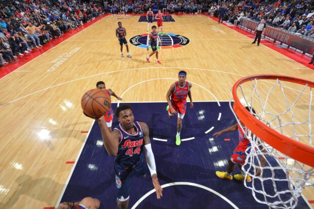 Philadelphia 76ers player attempting a layup during a basketball game against the Detroit Pistons