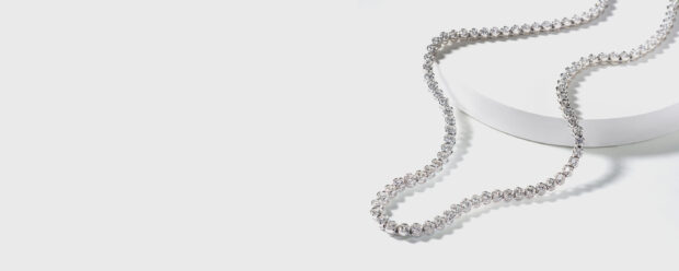A diamond jewelry necklace placed on a white surface showcasing elegant sparkle and luxury