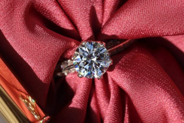 A sparkling diamond jewelry surrounded by red fabric folds