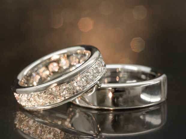 Diamond jewelry rings with sparkling diamonds on reflective surface