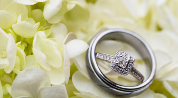 A diamond jewelry ring with floral details surrounded by white flowers