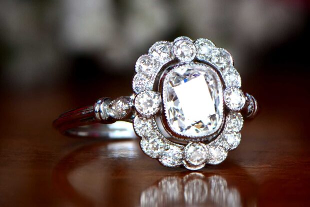 Close up of diamond jewelry ring with sparkling stones on wooden surface
