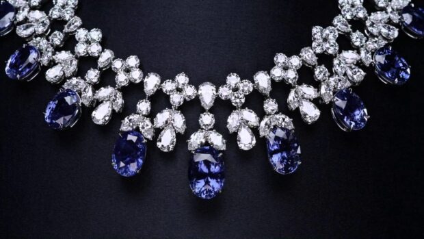 A luxury necklace featuring diamond jewelry and blue sapphires on black fabric