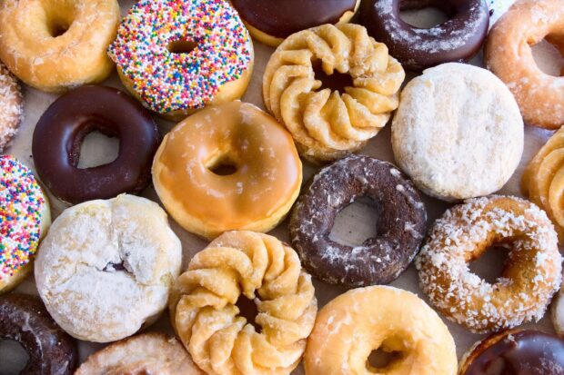 Various donut flavors and textures arranged closely on a surface showcasing a variety of donuts