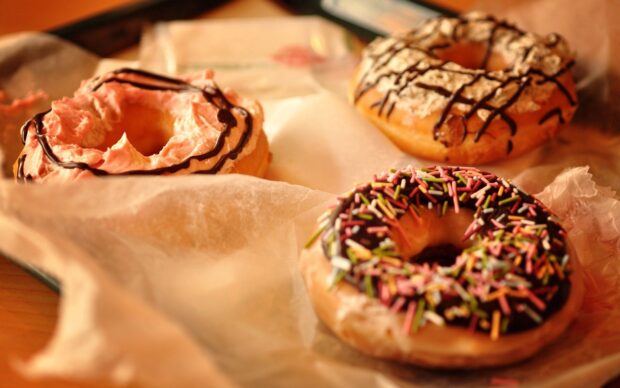 A variety of colorful donut toppings featuring sprinkles and icing on a soft pastry