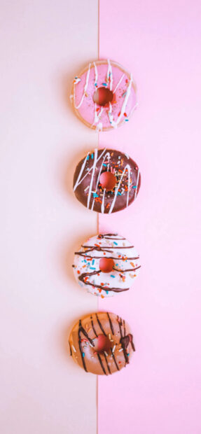 Four colorful donut varieties arranged vertically on a pink and beige split background