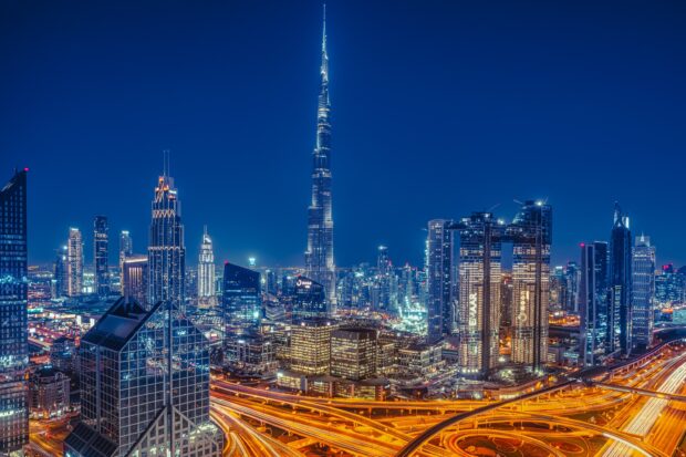 Dubai skyline with illuminated skyscrapers and highways at night showcasing modern architecture