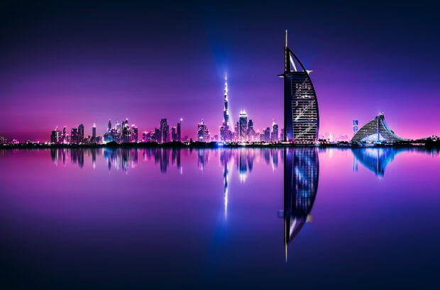 Stunning Dubai skyline with illuminated skyscrapers reflected on calm water at twilight
