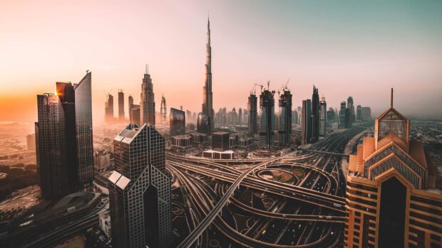 The Dubai cityscape showing iconic buildings and complex highways at sunset with the skyline in clear view