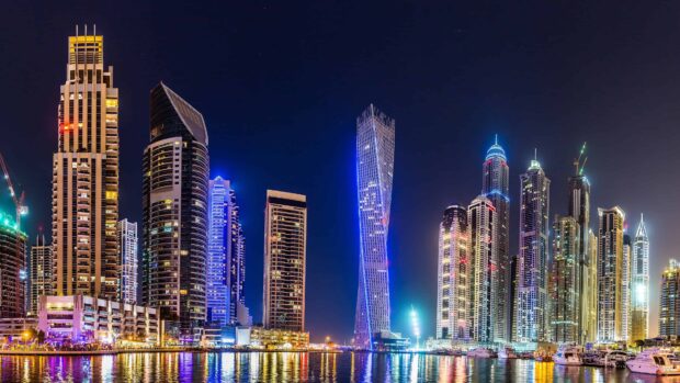 Dubai skyline with twisting tower and illuminated high rise buildings at night
