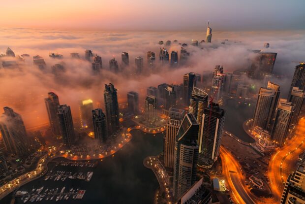 Dubai skyline with high rise buildings covered in fog during sunset view