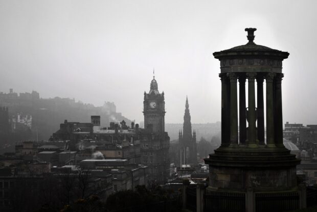 Edinburgh skyline featuring historical buildings and monuments in a foggy atmosphere