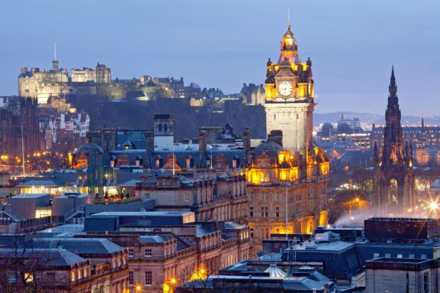 Historic Edinburgh skyline with clock tower and castle at dusk featuring iconic architecture