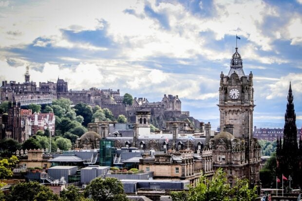Historic Edinburgh skyline with iconic buildings and castle under cloudy sky