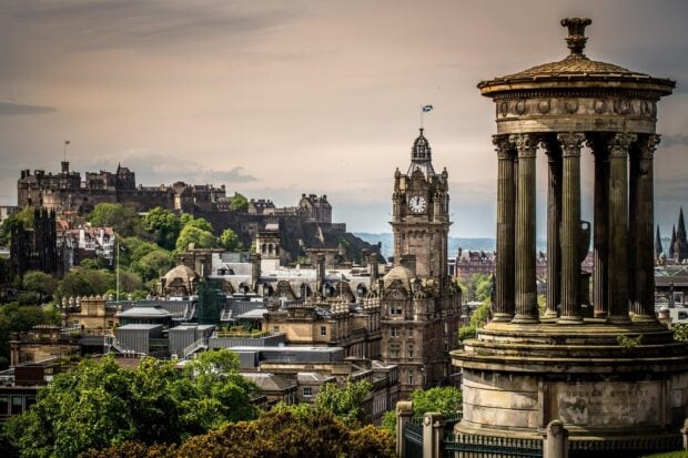 The historic Edinburgh skyline featuring castle and monument under cloudy sky