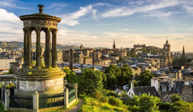 Edinburgh skyline featuring Dugald Stewart monument and historic cityscape in golden hour light