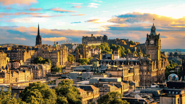 Edinburgh skyline featuring historic architecture and landmarks under a dramatic sunset sky
