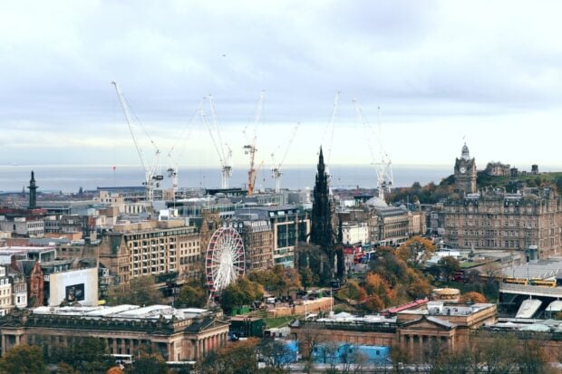 Edinburgh skyline featuring historic buildings and a ferris wheel during autumn