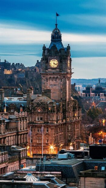 Historic clock tower in Edinburgh skyline at dusk showing famous cityscape