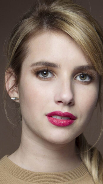Close up of Emma Roberts with braided hair and bright pink lipstick