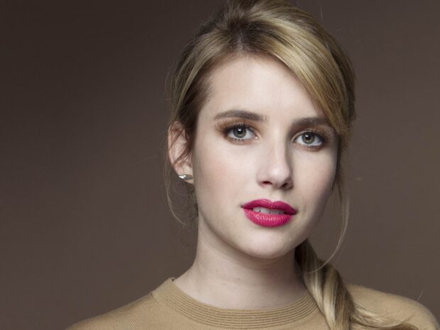 Close up of Emma Roberts with bright lipstick and blonde hair pulled back