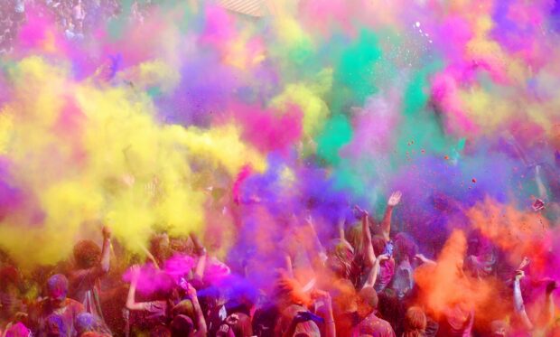 People celebrating with colorful powders during a festival celebration