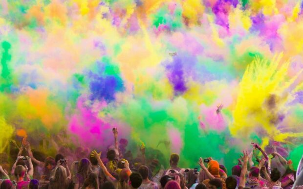 People celebrating with colorful powder at festival event