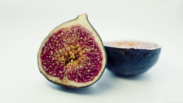 Close up of a juicy fig cut in half showing its detailed interior seeds and flesh