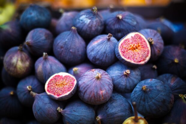 Fresh figs with vibrant purple skin and red interior filling the frame in HD quality