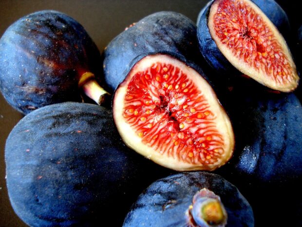 Close up of fig fruit showing the detailed red interior and dark purple skin