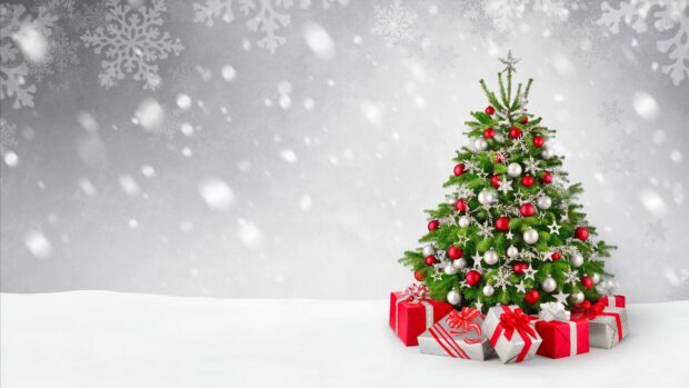 A decorated fir tree with red and silver ornaments surrounded by wrapped gifts on snow