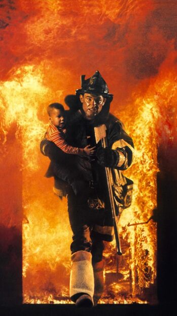 Fireman carrying a child out of a burning building during a rescue operation