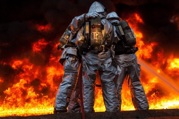 Fireman wearing protective suits fighting fire in a dangerous blaze