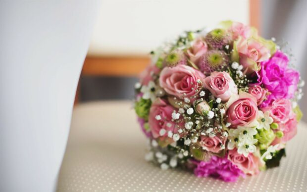 A beautiful flower bouquet with pink roses and white blossoms on a soft surface