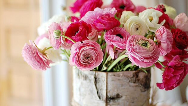 A beautiful flower bouquet with pink and white blossoms in a rustic wooden vase