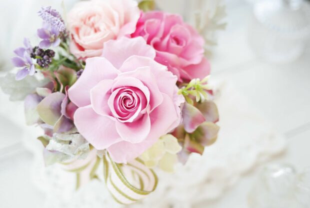 A delicate flower bouquet featuring various pink and purple blooms and green foliage