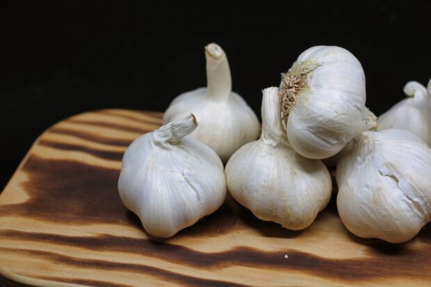 Several garlic bulbs placed on a wooden surface in high definition quality