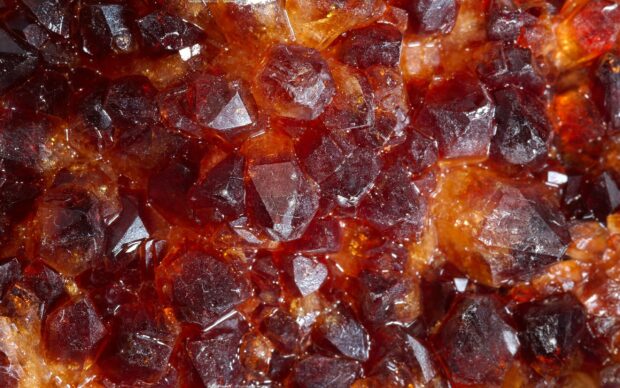 Close up of red gemstone crystals with detailed textures and vibrant colors