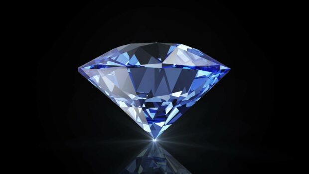 A blue gemstone sparkling vividly on a reflective black surface