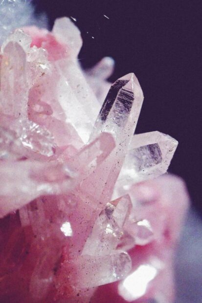 Close up of gemstone crystals with pink hues and clear points