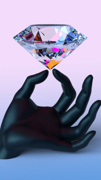 A black hand holding a large sparkling gemstone suspended against a pastel background