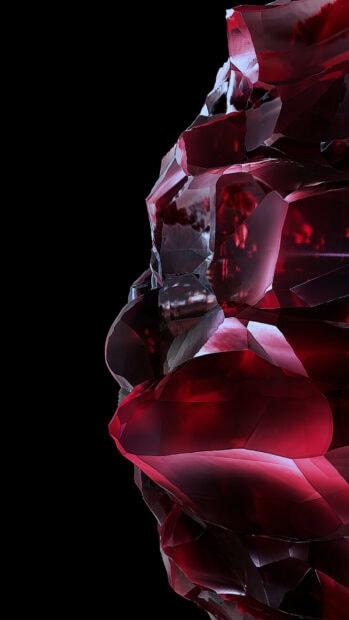 Close up of red gemstone with intricate crystal details on black background