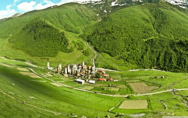A scenic village with ancient towers surrounded by green hills in Georgia