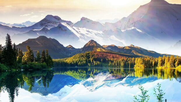 Snowy mountain ranges and green forest reflections in a clear lake of Georgia