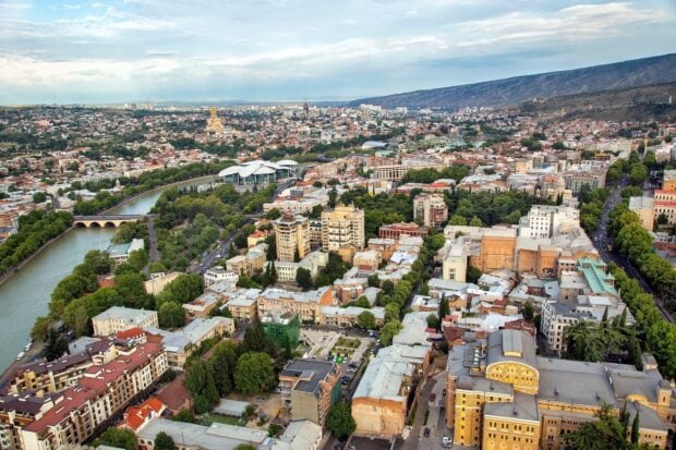 Aerial view of Georgia cityscape featuring buildings and a river under a cloudy sky